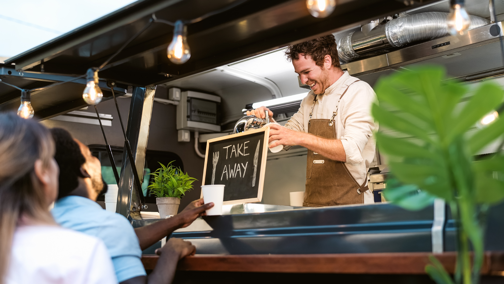 Ristorante pop-up estivo all’aperto con tavoli in legno, clienti rilassati e staff che prende ordini con tablet e sistema di cassa cloud.